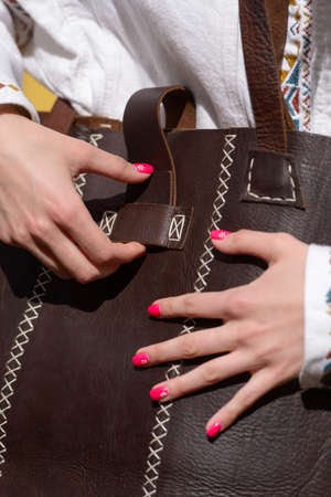 Part photo of a leather shopping bag with antique and retro look. Outdoors photo