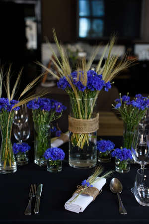 A set of furniture in a cafe. Vase with flowers decor for the restaurant. Black tablecloth