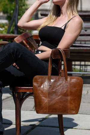 close-up photo of brown leather bag on a wooden chairの写真素材