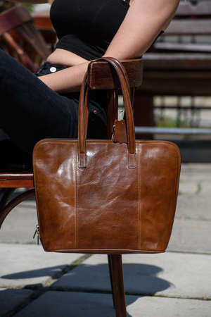 close-up photo of brown leather bag on a wooden chairの写真素材