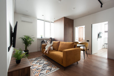 beautiful woman reading a magazine in the kitchen. apartment after renovationの写真素材