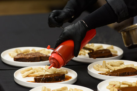 chef is serving pasticada with gnocchi, beef stew in a sauce. Croatian cuisineの写真素材