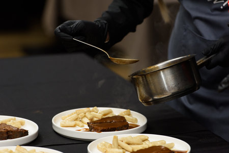 chef is serving pasticada with gnocchi, beef stew in a sauce. Croatian cuisineの写真素材