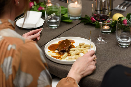 Woman eating pasticada with gnocchi, beef stew in a sauce. Croatian cuisineの写真素材