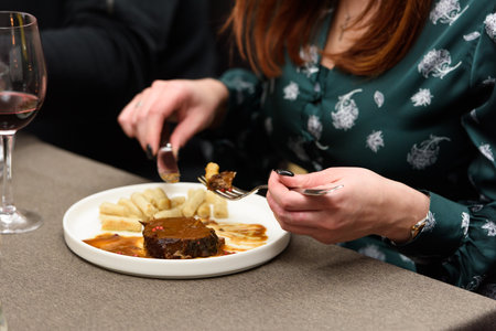 Woman eating pasticada with gnocchi, beef stew in a sauce. Croatian cuisineの写真素材