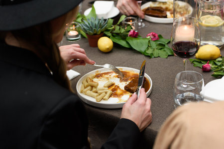 Woman eating pasticada with gnocchi, beef stew in a sauce. Croatian cuisineの写真素材