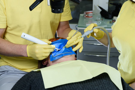 Close-up shot of attentive doctors performing surgical operation installing dental implants into patients mouth in modern dental clinic.の写真素材