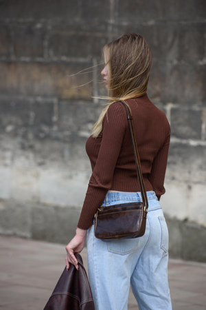 close-up photo of small brown leather bag in a woman handsの写真素材