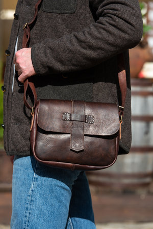 close-up photo of brown messanger leather bag on mans shoulderの写真素材