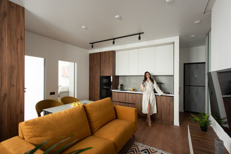 beautiful woman stand with a cup of tea in hands in the kitchen. apartment after renovationの写真素材