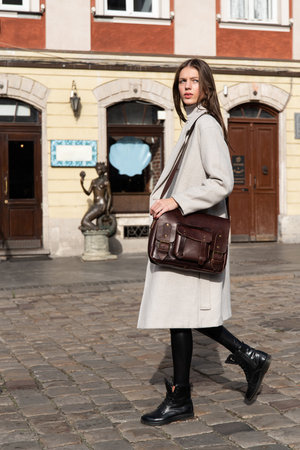 photo of a woman with a brown leather briefcase with antique and retro look. Outdoors photoの写真素材