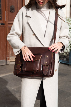 photo of a woman with a brown leather briefcase with antique and retro look. Outdoors photoの写真素材
