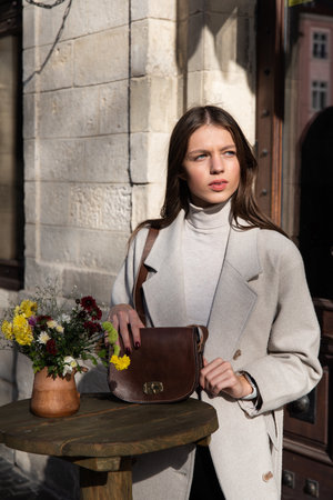 photo of a woman with a brown leather handbag with retro look. Outdoors photoの写真素材