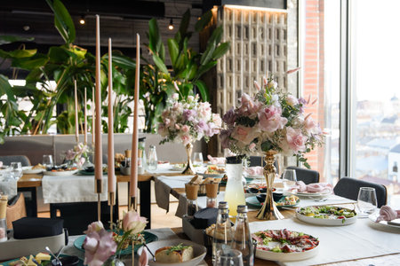 served table in the restaurant is decorated with a luxurious bouquet. Garden roses, eustoma, populus eucalyptus. pastel coloursの写真素材
