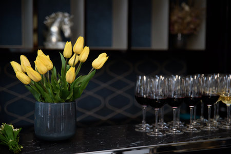 Beautiful spring bouquet of yellow tulips in a gray vase. vase with tulips in a dark roomの写真素材