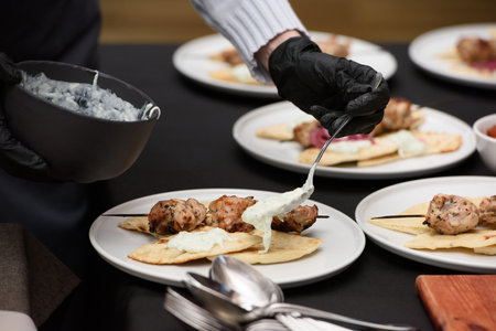 the chef in the restaurant prepares souvlaki with pita and tzatziki sauceの写真素材
