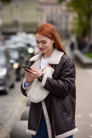 happy woman communicates with friends via video link outdoors on an old town streetの写真素材