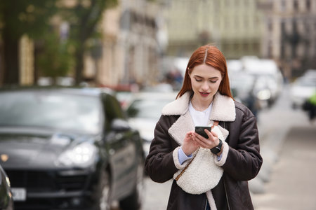 happy woman communicates with friends via video link outdoors on an old town streetの写真素材