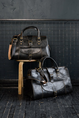 black leather travel bags indoors photo on black backgroundの写真素材