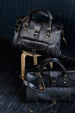 black leather travel bags indoors photo on black backgroundの写真素材