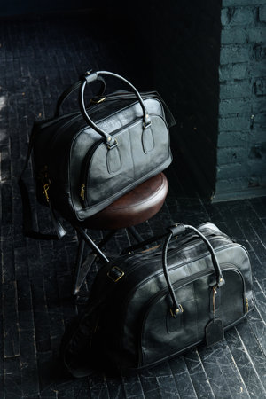 black leather travel bags indoors photo on black backgroundの写真素材
