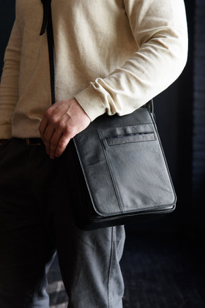 close-up photo of black messanger leather bag on mans shoulderの写真素材