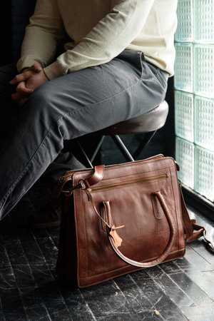 close-up photo of light brown leather briefcase on a black wooden floor.の写真素材
