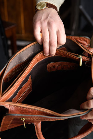 top view of open empty leather bag in mans handsの写真素材