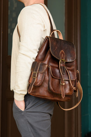 Brown leather oldfashioned backpack on a mans backの写真素材