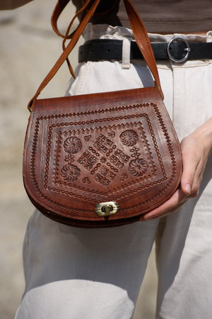 small light brown womens leather bag with a carved pattern. selective focusの写真素材