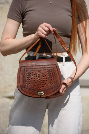 small light brown womens leather bag with a carved pattern. selective focusの写真素材