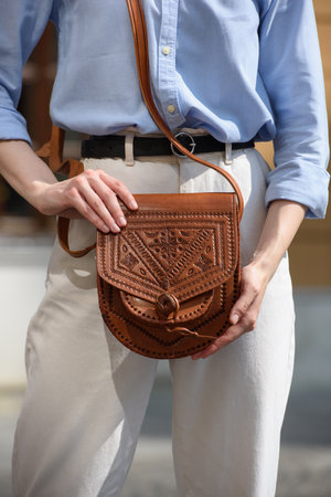small light brown womens leather bag with a carved pattern. selective focusの写真素材