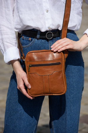 photo of a woman with a small brown leather bag.の写真素材