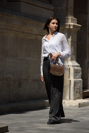 Street photo of young beautiful woman wearing stylish classic clothes. Full body portrait. Female fashion concept.の写真素材