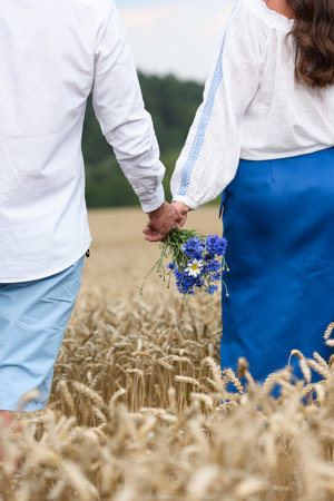 Couple dressed in traditional Ukrainian clothes holding their hands together. Ethnic wedding in national costumes.の写真素材