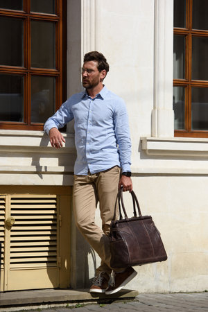 Handsome businessman walking on the street, with luxury brown leather briefcase. Fashionable style.の写真素材