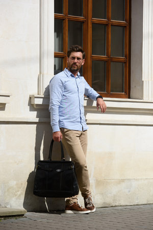 Handsome businessman walking on the street, with luxury brown leather briefcase. Fashionable style.の写真素材