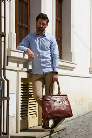 Handsome businessman walking on the street, with luxury leather briefcase. Fashionable style.の写真素材