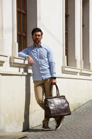 Handsome businessman walking on the street, with luxury leather briefcase. Fashionable style.の写真素材