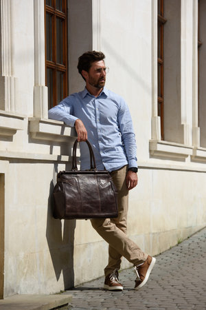 Handsome businessman walking on the street, with luxury leather briefcase. Fashionable style.の写真素材