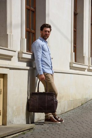 Handsome businessman walking on the street, with luxury leather briefcase. Fashionable style.の写真素材