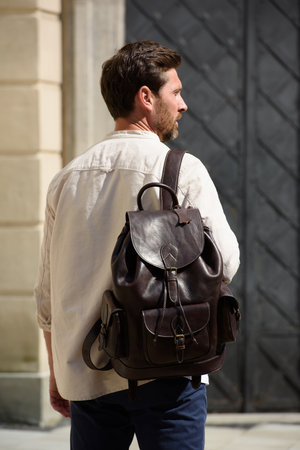 Handsome businessman walking on the street, with luxury leather dark brown backpack. Fashionable style.の写真素材