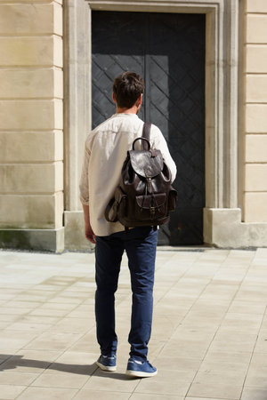 Handsome businessman walking on the street, with luxury leather dark brown backpack. Fashionable style.の写真素材