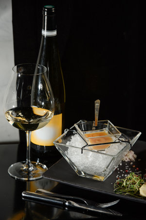 Pike fish caviar, on ice, with croutons, lemon, on a transparent dish, on a dark backgroundの写真素材