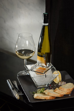Pike fish caviar, on ice, with croutons, lemon, on a transparent dish, on a dark backgroundの写真素材