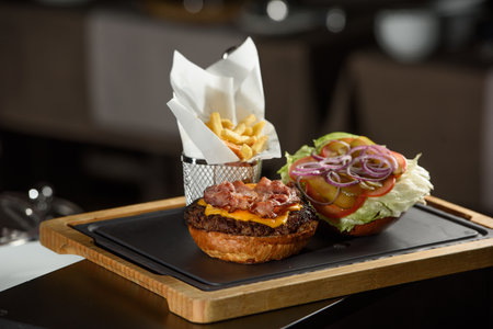 fresh tasty burger and french fries on wooden deskの写真素材