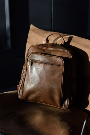 Brown leather backpack on chair, close up.の写真素材