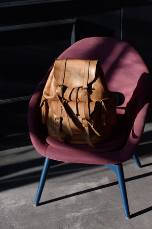 Brown leather backpack on chair, close up.の写真素材