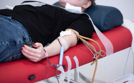 view of donor giving blood at donation centerの写真素材