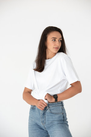 Happy beautiful girl posing in a new hot summer look. Wearing blue jeans and white t-shirtの写真素材